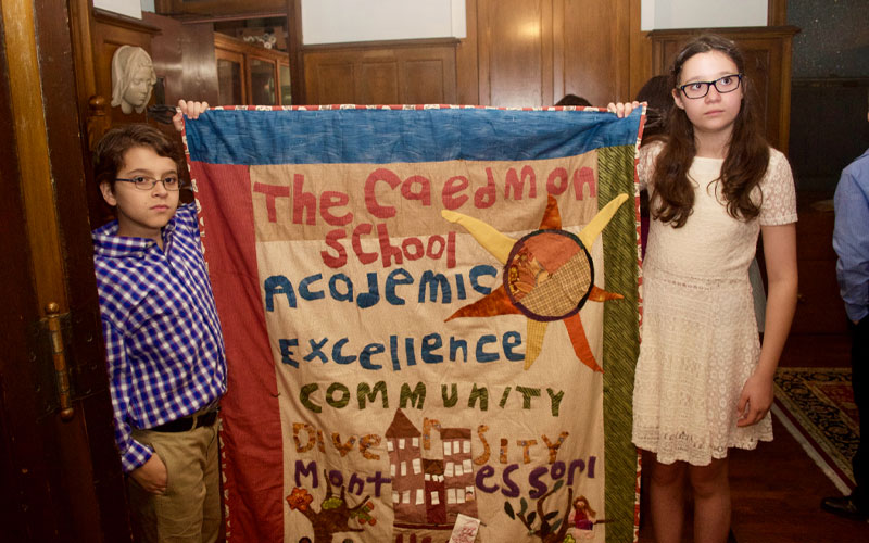 Caedmon students holding a textile art they've made.