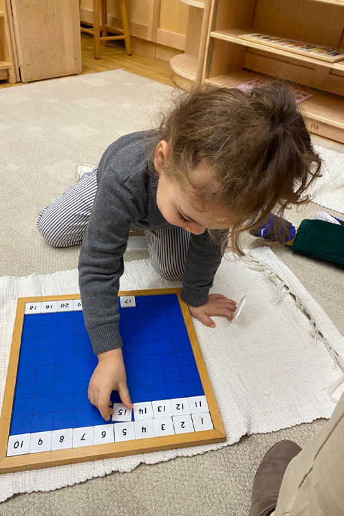 Beginner student at Caedmon School playing with an educational toy