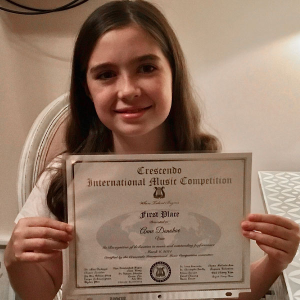 Annie Donohoe, student at The Caedmon School, with a certificate for a music award she won first place in