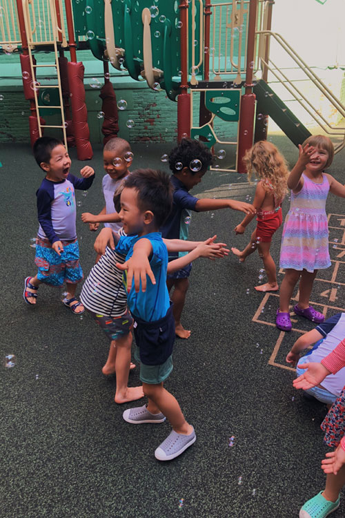 Students playing with bubbles in a play area at discovery camp