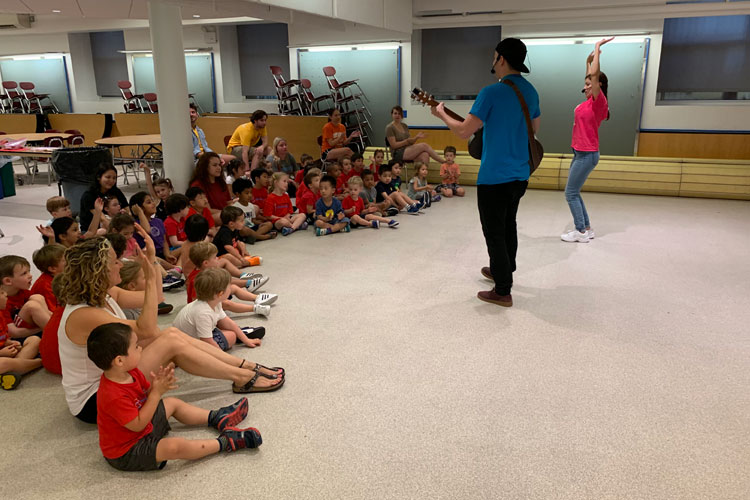 Students at discovery camp listening to music being played by staff